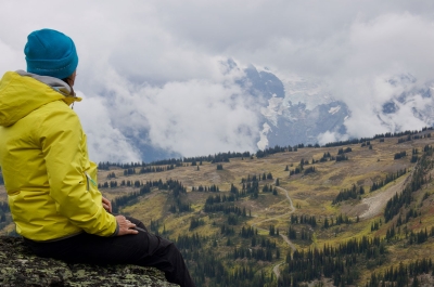A person sitting on a mountain top enjoying the view.