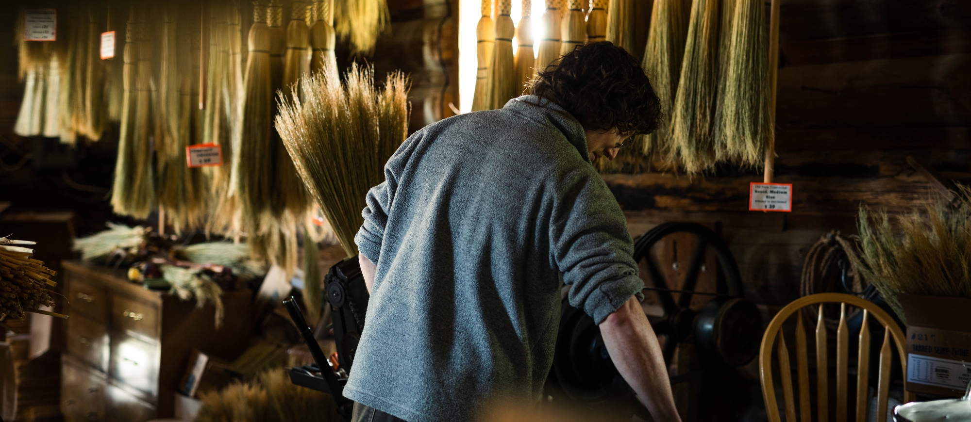 Local broom-maker, Luke, weaving a broom.