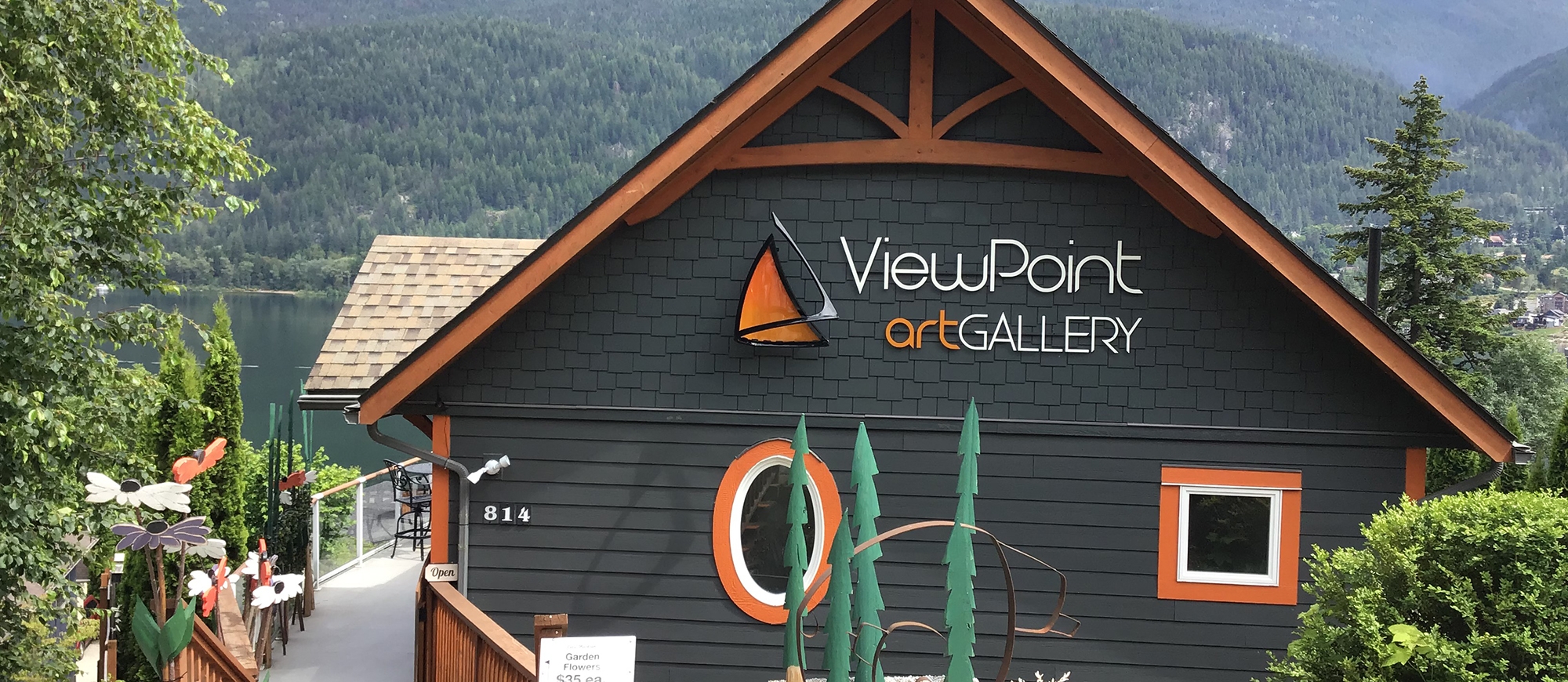 the Viewpoint Art Gallery building sitting above Kootenay Lake with mountains in the background
