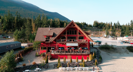 The big, red building of The Landing with people dining on their patio.