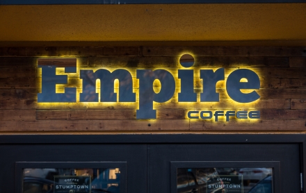 The Empire Coffee sign lit up on the outside of the building