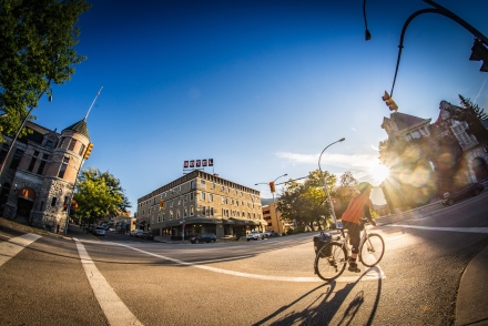 Man biking downtown Nelson with The Hume Hotel and the court house in the background