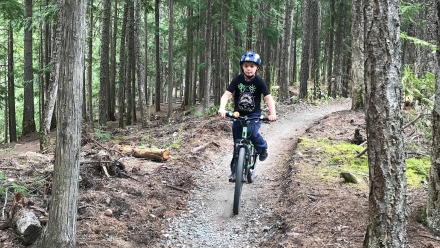 A boy riding his bike at the Kaslo Pump Track.