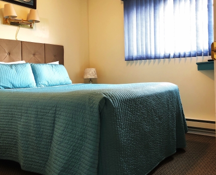 a bed with blue sheets in a room at Kokanee Glacier Resort