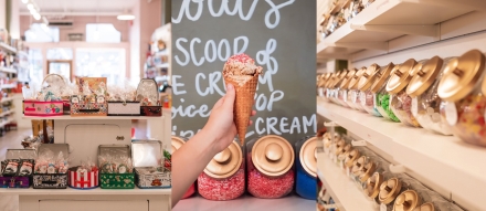 Inside of candy store and a hand holding an ice cream cone with sprinkles.