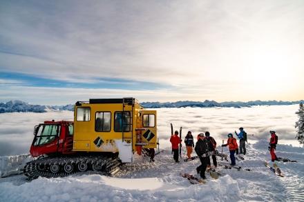 A Snowcat and skiiers in the snow at Selkirk Snowcat Skiing