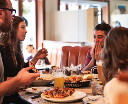 four people enjoying food and drinks at Uptown Sportsbar in Nelson, BC