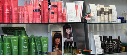 Hair products displayed on a shelf inside a salon.