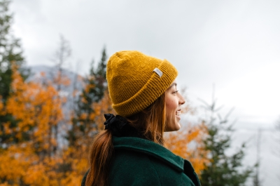 A girl looking out onto Kootenay Lake with fall colours around her.
