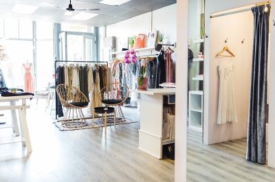 Clothing racks and wickers chairs in the bright daylight at Scout Clothing. 