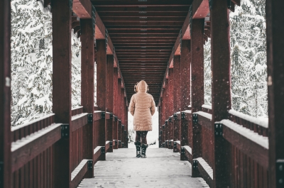 Person walking across one of the red bridges on the Kaslo River Trail