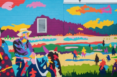 A colourful mural depicting a cowboy and first nations peoples called Dispossessed, Unvanquished by Jean Paul Langlois in Nelson. Photo by David R. Gluns Photography, courtesy of the City of Nelson.