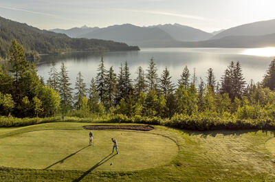 A couple golfing beside Kootenay Lake BC.