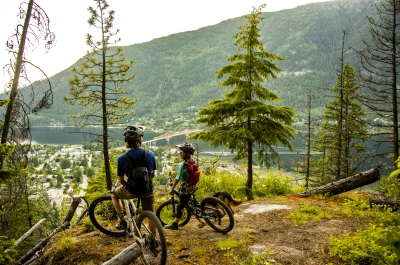Two kids looking out onto Nelson BC from the Hippie Killer mountain biking trail.