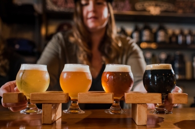 A bartender offers a flight of beer.