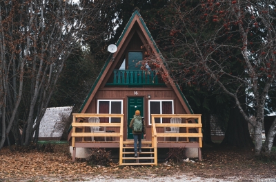 A person walking up the steps to a cute cabin.