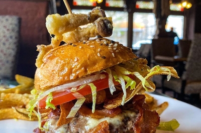 A speciality burger on a plate in Mike's Place pub for Nelson BC's 2020 Burger Month