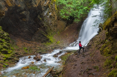 A hiker standing in front on the Insta-worthy Fletcher Falls near Kaslo, BC