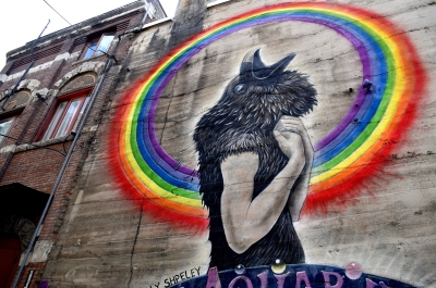 A mural  of a black bird head on a human's body from the Nelson BC Mural Festival