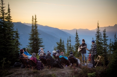 Artist Tenise Marie singing to a small crowd on the top of Mt Buchanan in Kaslo, BC at sunset.