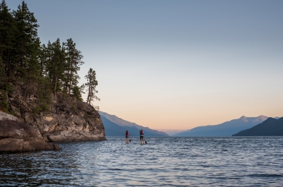 Two stand up paddle boarders on the East Shore of Kootenay Lake, BC.