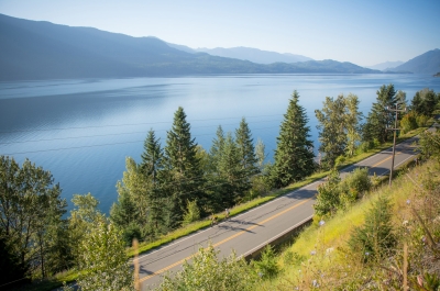 Two cyclists riding along the Highway near Kaslo, BC