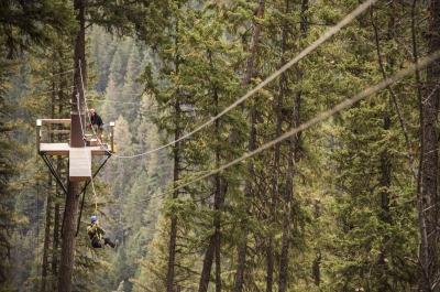 A person zip lining through the trees at Kokanee Mountain Zipline in Nelson, BC.