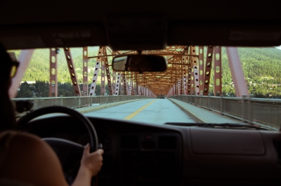 Girl driving over the big orange bridge in Nelson