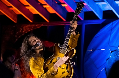 Guitarist playing music in an indoor venue.