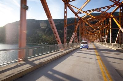 A VW bus driving across the Big Orange Bridge in Nelson, BC. 