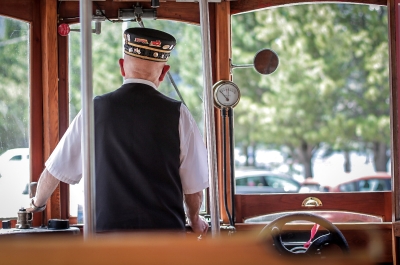 Looking through the front windows of Streetcar #23 with the driver in uniform in the foreground.