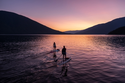 Two paddle boarders on Kootenay Lake paddling into the sunset