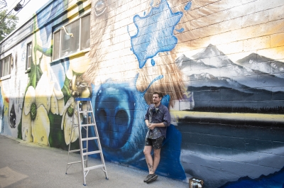 Artist Jerome Davenport stands in front of his mural at the 2018 Nelson International Mural Festival.