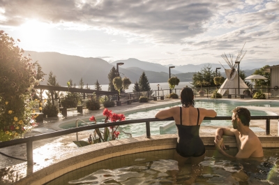 Bathers enjoying swimming at Ainsworth Hot Springs Resort with a view of Kootenay Lake.