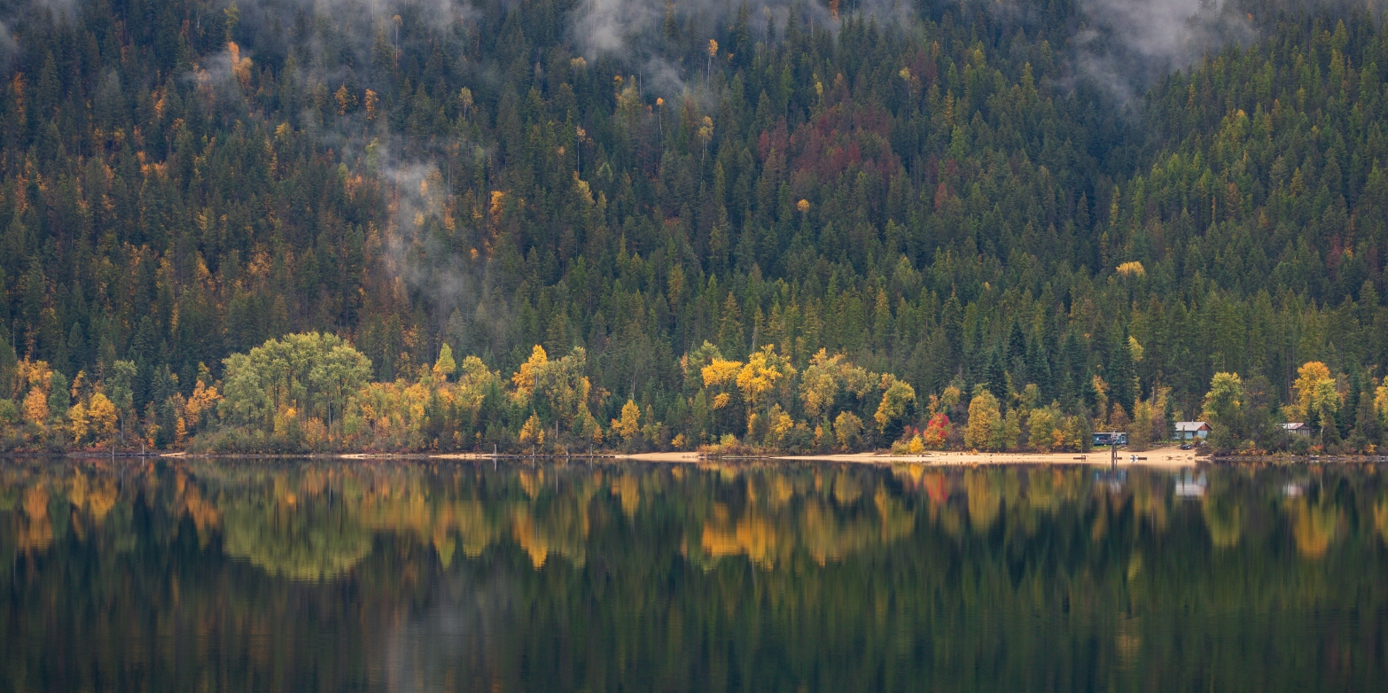 Fall colours reflecting on lake.