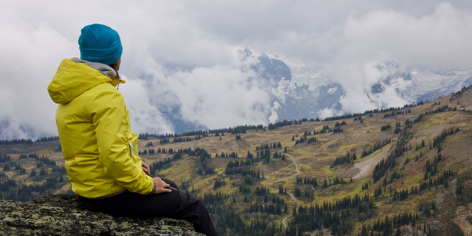 A person sitting on a mountain top enjoying the view.