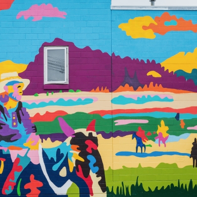 A colourful mural depicting a cowboy and first nations peoples called Dispossessed, Unvanquished by Jean Paul Langlois in Nelson. Photo by David R. Gluns Photography, courtesy of the City of Nelson.