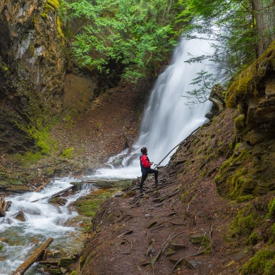 A hiker standing in front on the Insta-worthy Fletcher Falls near Kaslo, BC