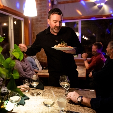 Diners enjoying food at night at Sage Taps and Wine Bar in Nelson, BC