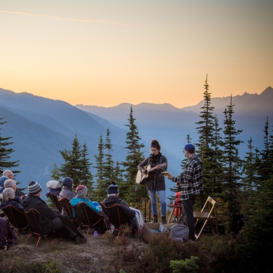 Artist Tenise Marie singing to a small crowd on the top of Mt Buchanan in Kaslo, BC at sunset.