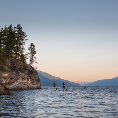 Two stand up paddle boarders on the East Shore of Kootenay Lake, BC.