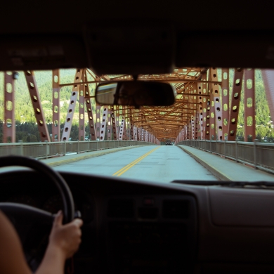 Girl driving over the big orange bridge in Nelson