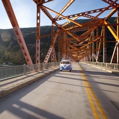 A VW bus driving across the Big Orange Bridge in Nelson, BC. 