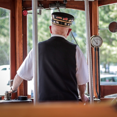 Looking through the front windows of Streetcar #23 with the driver in uniform in the foreground.