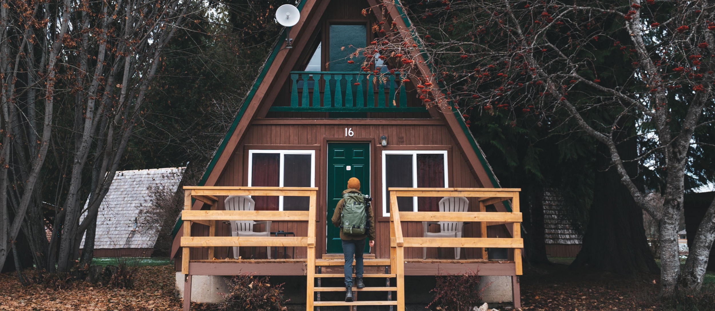 Person walking up the front steps to a cozy cabin.