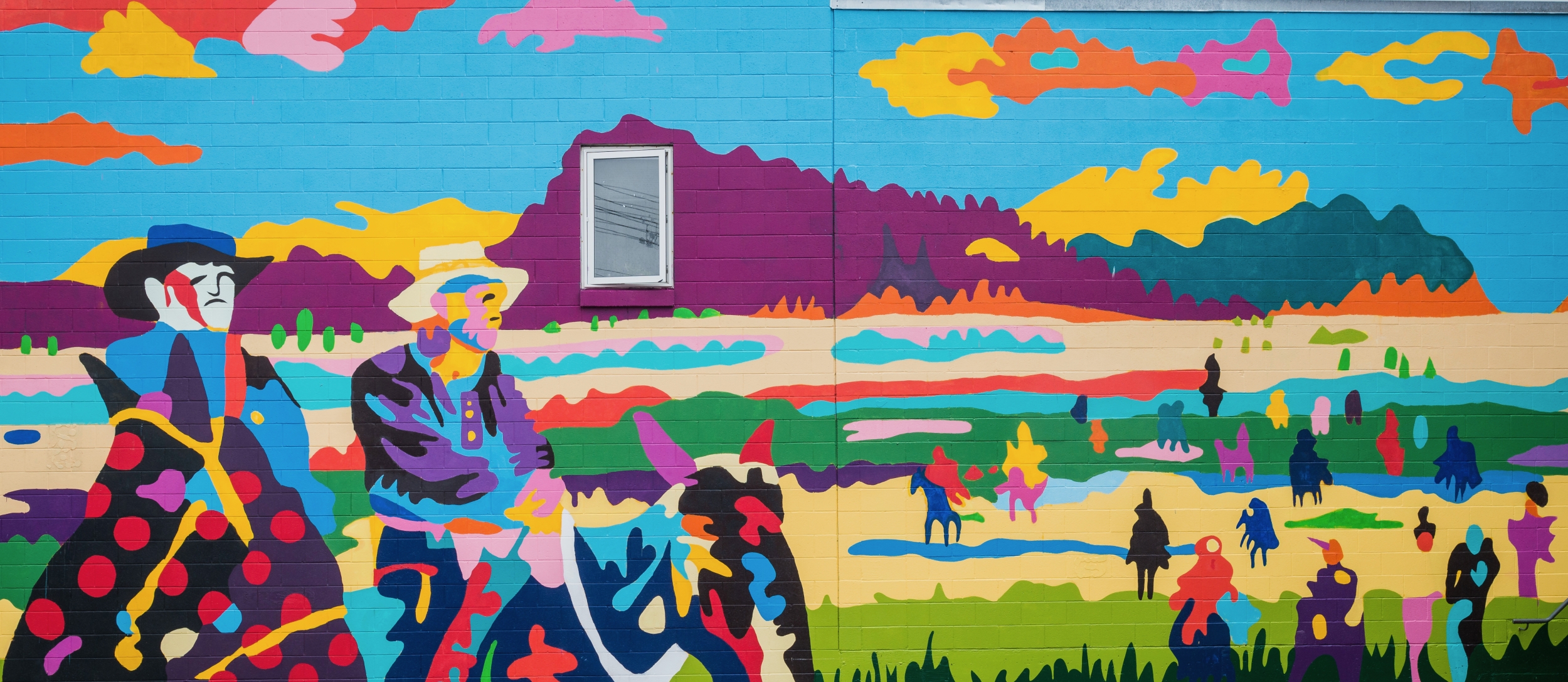 A colourful mural depicting a cowboy and first nations peoples called Dispossessed, Unvanquished by Jean Paul Langlois in Nelson. Photo by David R. Gluns Photography, courtesy of the City of Nelson.