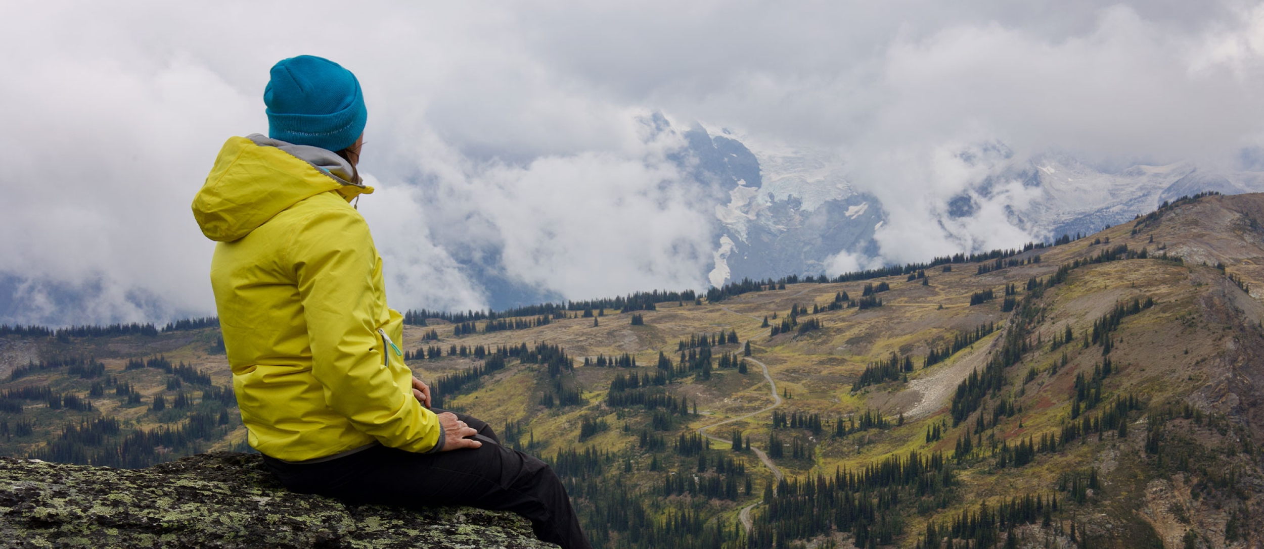 A person sitting on a mountain top enjoying the view.