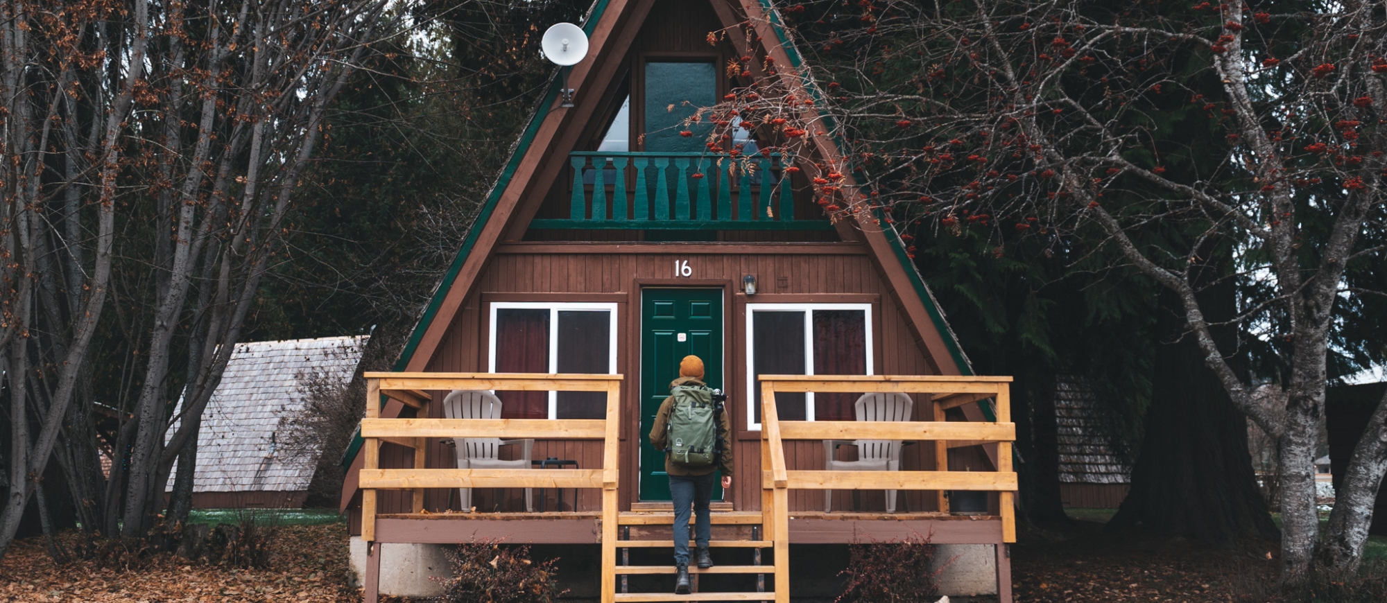 A person walking up the steps to a cute cabin.