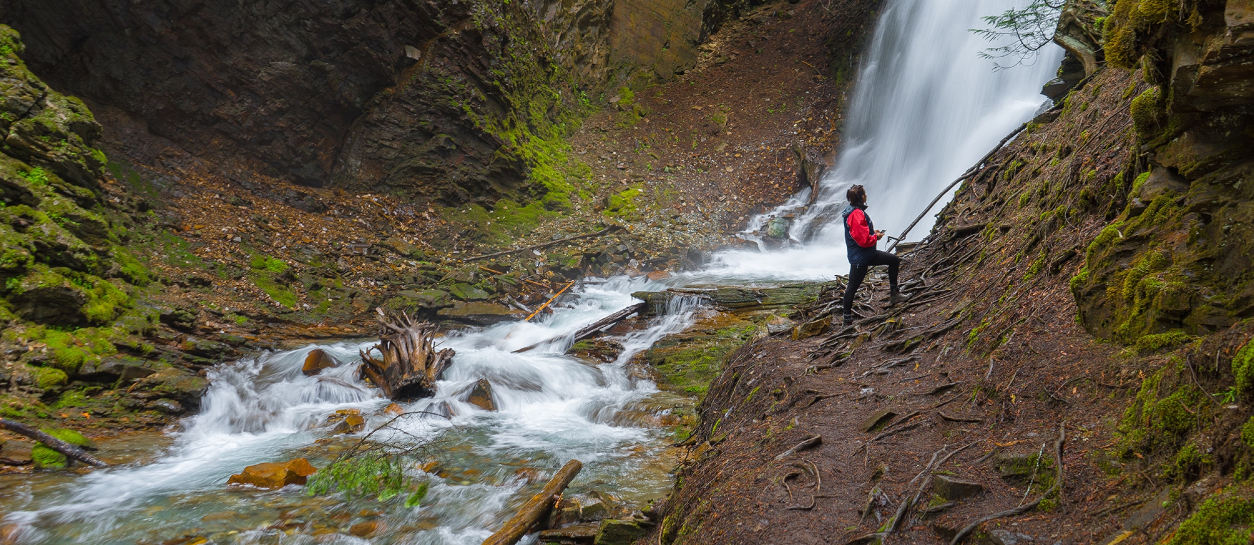 A hiker standing in front on the Insta-worthy Fletcher Falls near Kaslo, BC