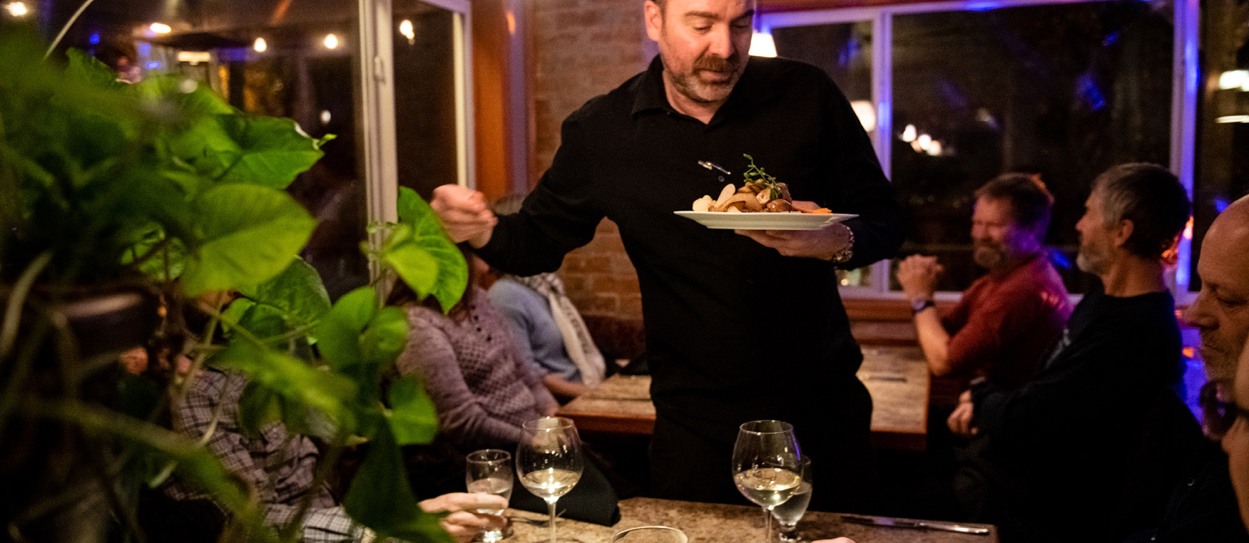 Diners enjoying food at night at Sage Taps and Wine Bar in Nelson, BC